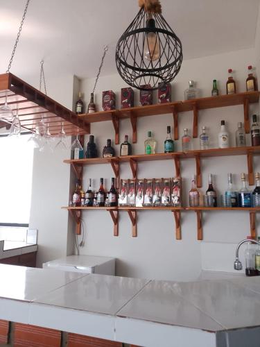 a kitchen with shelves of bottles and a chandelier at Hotel Ruah in Tumbes
