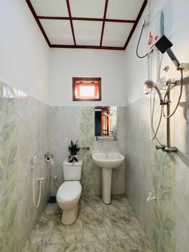 a bathroom with a toilet and a sink at Fourcoock Villa in Kosgoda