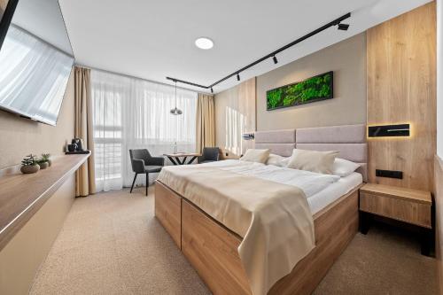 a bedroom with a large bed and a table at Hotel Vega Luhacovice in Luhačovice