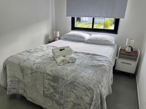 a bedroom with a bed with a laptop on it at Condomínio Noruega - casas 2 dormitórios in Jaguarão