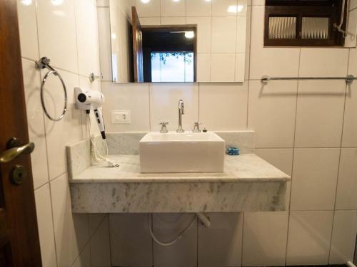 a bathroom with a white sink and a mirror at Deck Picinguaba Pousada in Picinguaba