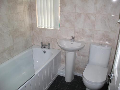a bathroom with a sink and a toilet and a bath tub at The Grange in Middlesbrough