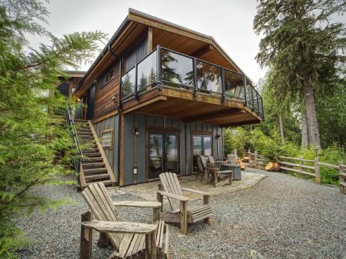 a house with a deck and some chairs at Going Coastal ABC - Oceanfront - Pet Friendly in Port Renfrew