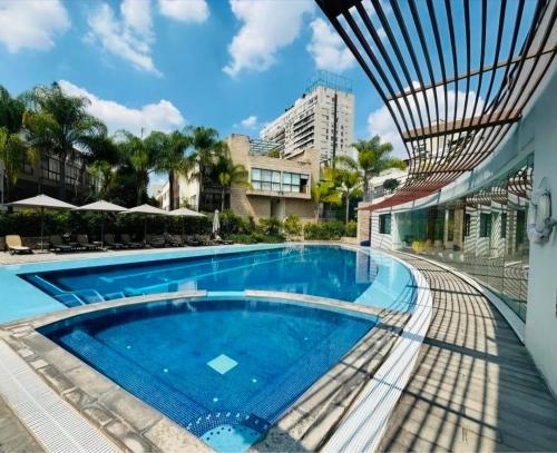 a swimming pool at a resort with a building at Amazing pool in the middle of the city in Mexico City