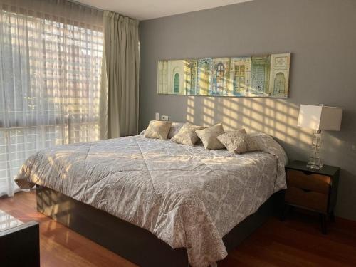 a bedroom with a bed with pillows on it at Amazing pool in the middle of the city in Mexico City