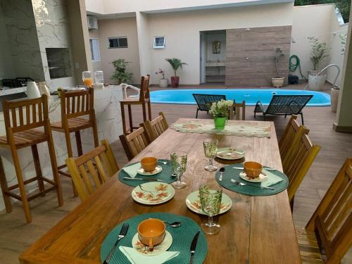 a wooden table with plates and glasses on top at Pousada Recanto Populina in Populina