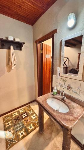 a bathroom with a sink and a mirror at Amazing house with chalet and a beautiful garden in Sêrro