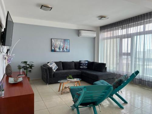 a living room with a black couch and chairs at Depto Excelente ubicación Vista parcial Mar in Boca del Río