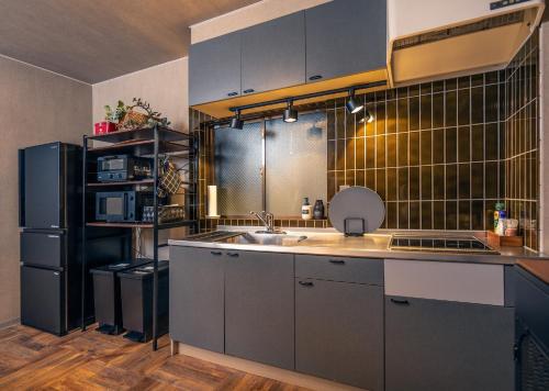 a kitchen with a sink and a refrigerator at Kawaramachi Grande Joy in Takamatsu
