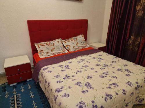a bedroom with a bed with a red headboard at Dar Mima in Tunis