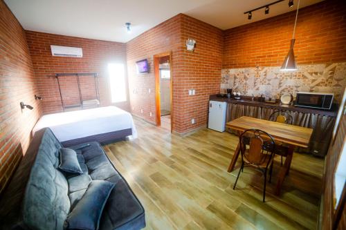 a room with a bed and a couch and a table at ChapadaFlats in Chapada dos Guimarães
