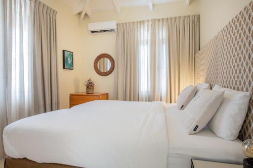 a white bed with white pillows in a bedroom at Curacao Luxury Holiday Rentals in Willemstad