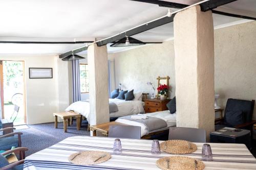 a hotel room with two beds and a bedroom at Douglas Drift Cottages in Underberg