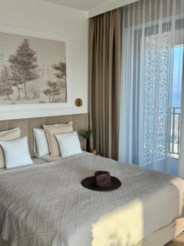 a bedroom with a bed with a hat on it at Baltic Infinity Garden Suite 316 - SPA & Pool Access in Międzyzdroje