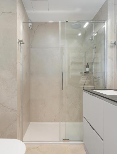 a glass shower in a bathroom with a sink at Baltic Infinity Garden Suite 316 - SPA & Pool Access in Międzyzdroje