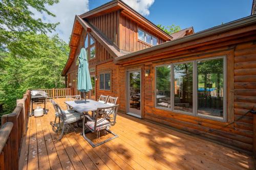 a wooden deck with a picnic table and an umbrella at The Hygge Chalet by Railey Vacations in McHenry