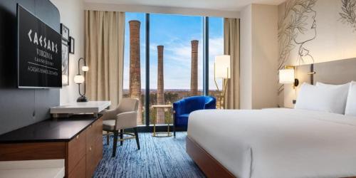 ein Hotelzimmer mit Bett und Schreibtisch und ein Zimmer mit Fenster in der Unterkunft Caesars Virginia Hotel & Casino - A Caesars Rewards Destination in Danville