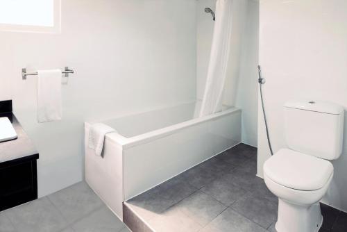 a bathroom with a toilet and a bath tub at Emirates Plaza Hotel in Abu Dhabi