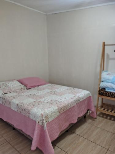 a bedroom with a bed and a chair at Apartamento sossegado e bairro tranquilo in Torres