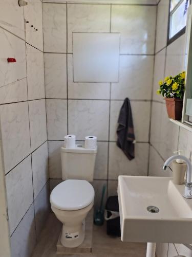 a bathroom with a white toilet and a sink at Apartamento sossegado e bairro tranquilo in Torres