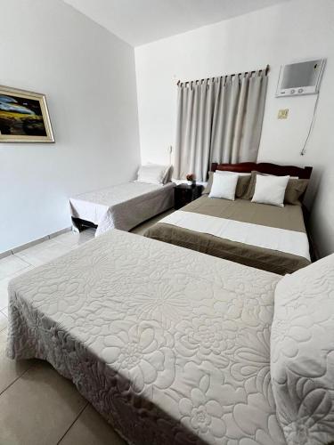 a hotel room with two beds in it at Pousada Sol Nascente in Mucuri