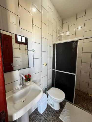 a bathroom with a sink and a toilet at Pousada Sol Nascente in Mucuri