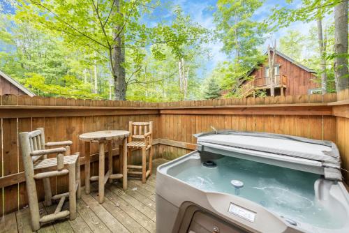 a hot tub on a deck with a table and chairs at The Grizzly Den by Railey Vacations in Oakland