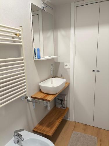 a white bathroom with a sink and a mirror at Zuretti House in Milan
