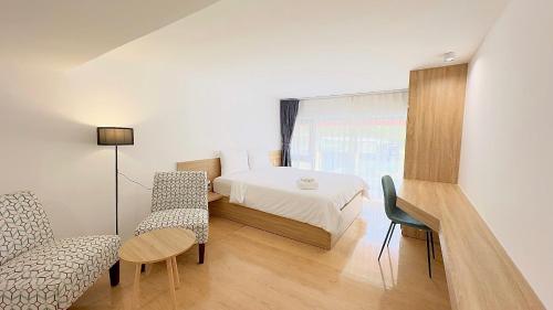 a bedroom with a bed and a chair and a table at Arista - Thanh My Loi in Ho Chi Minh City