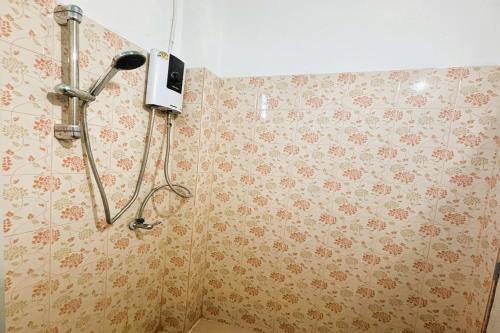 a shower in a bathroom with floral wallpaper at I Daa Pra-ea Guesthouse in Phra Ae beach