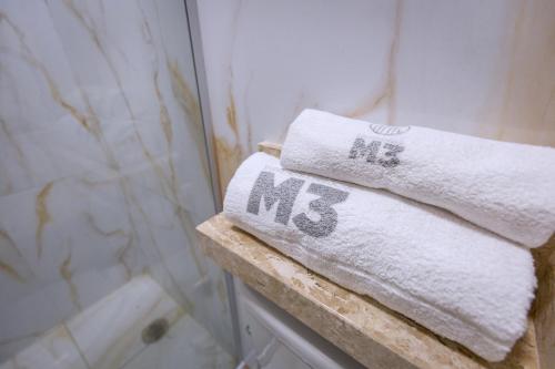 a couple of towels sitting on a shelf in a bathroom at M3 Studio Hotel in Camaçari