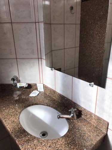 a bathroom with a sink and a mirror at Pousada Camping Quedasdagua in Barra do Rio Abaixo