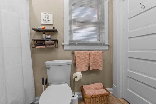 a bathroom with a toilet and a window and towels at Quiet 2BR Near Mercy Dog Friendly, Week & MO Rates in Springfield