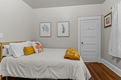 a white bedroom with a bed with yellow pillows at Quiet 2BR Near Mercy Dog Friendly, Week & MO Rates in Springfield