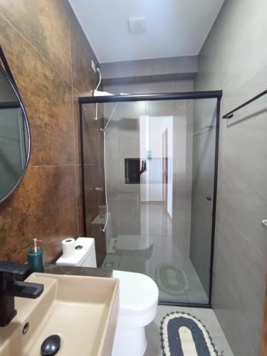 a bathroom with a shower and a toilet and a sink at Suíte 25 vista para o mar in Pontal do Paraná