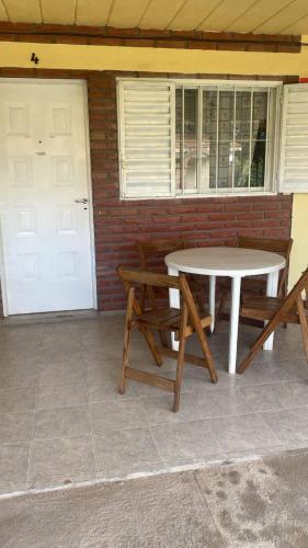 a table and benches on a patio with a door at El Pino Departamentos in Villa Cura Brochero