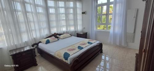 a bedroom with a bed in a room with windows at Life and memory in Blue Bay
