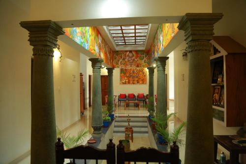 a hallway with columns and a brightly colored ceiling at Ayana's Homestay in Alleppey