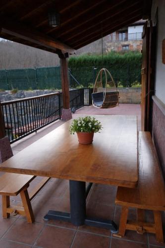 a wooden table with a potted plant on a patio at El eco de los robles in Sumbilla