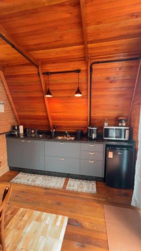 a kitchen with wooden walls and a wooden ceiling at Chalé Nascer do Sol 2 in Massaranduba