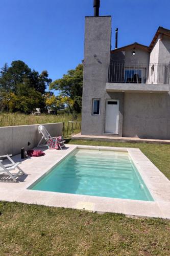 a swimming pool in front of a house at cabañas RIALTO in Villa Amancay