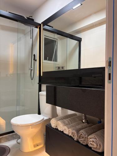 a bathroom with a toilet and a glass shower at Loft completo, garagem, piscina aquecida, jacuzzi in Porto Alegre