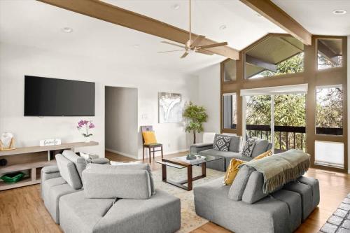a living room with two couches and a flat screen tv at High Country Rretreat in Flagstaff