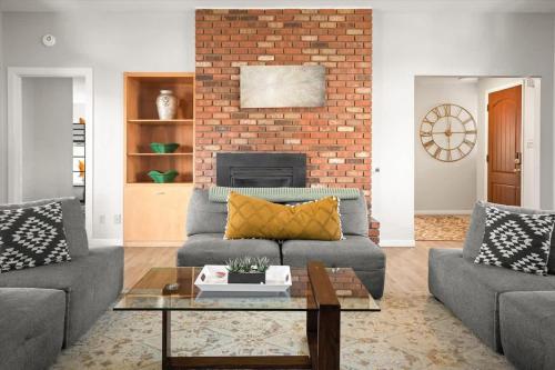 a living room with two couches and a brick wall at High Country Rretreat in Flagstaff