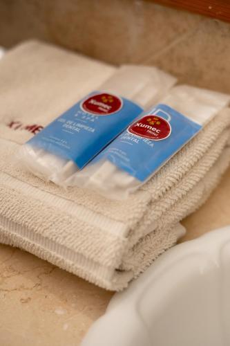 a pile of towels sitting on top of a sink at Hotel Xumec Mendoza Centro in Mendoza