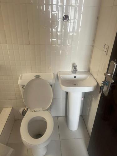 a small bathroom with a toilet and a sink at Otijoe Premier Hotel in Port Harcourt