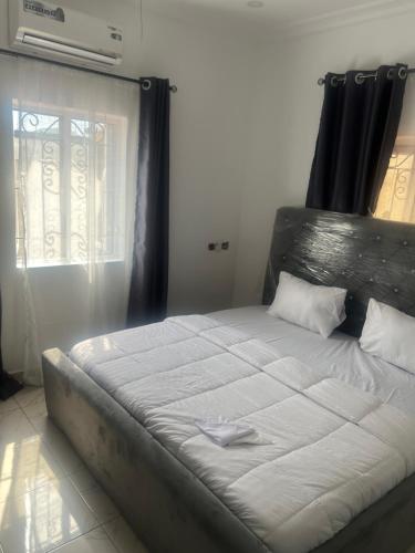a large bed in a room with a window at Otijoe Premier Hotel in Port Harcourt