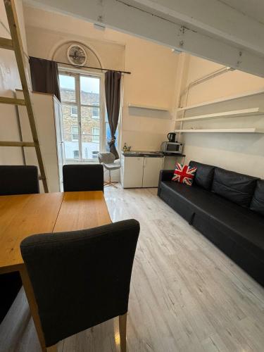 a living room with a black couch and a table at Rooms in Islington in London
