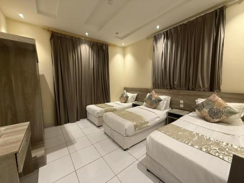 a hotel room with two beds and a couch at Marina Jada hotel in Jeddah