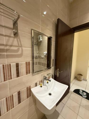 a bathroom with a sink and a mirror and a shower at Marina Jada hotel in Jeddah